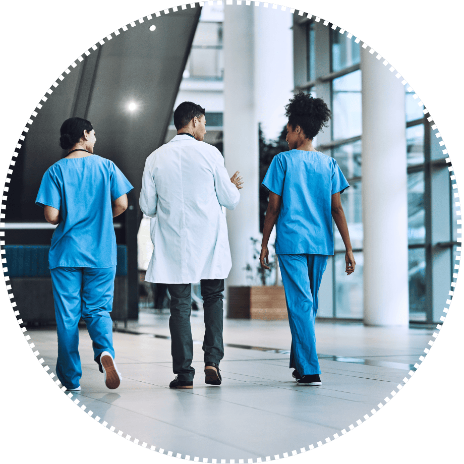 Three healthcare professionals walk together in a hospital hallway, symbolizing collaboration in rural health.